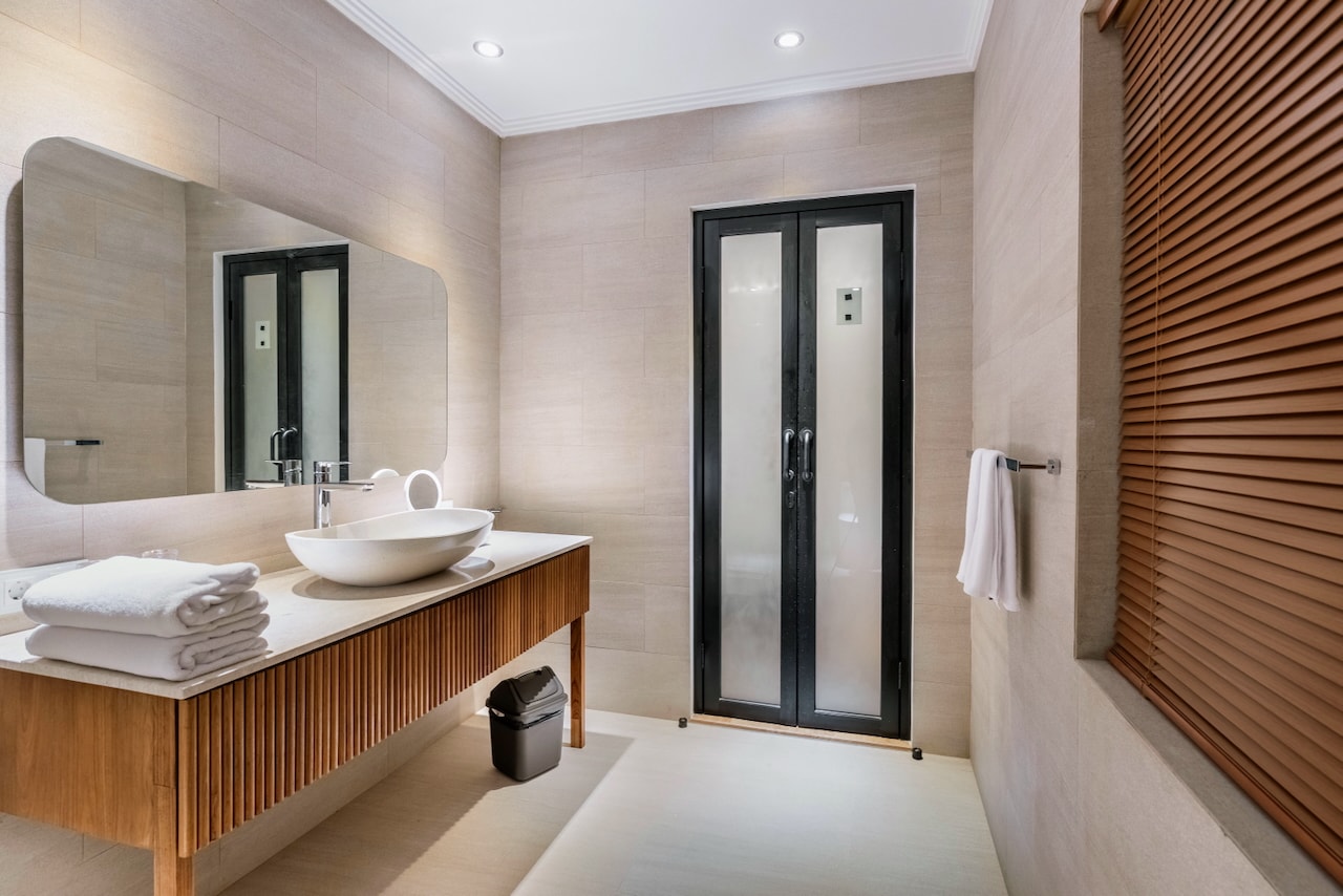 En-suite bathroom with rain shower beside the deluxe pool view bedroom