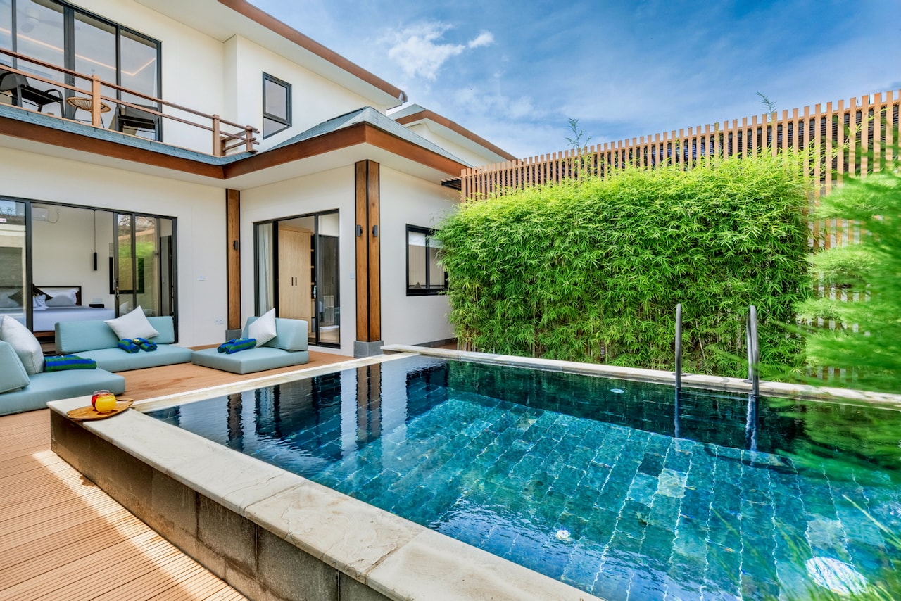 The green-stone pool and the daybeds on the deck below the balcony