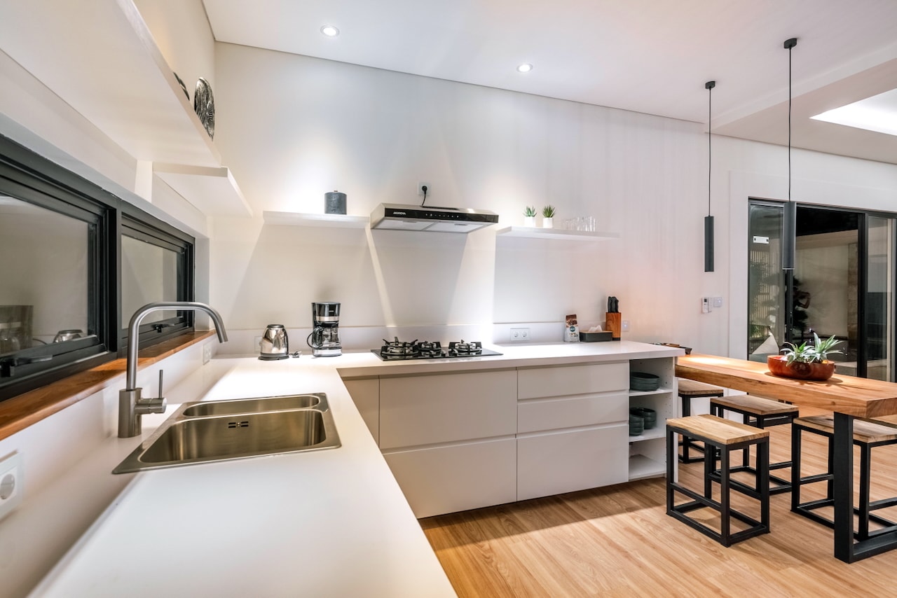 Sink, gas hob and bar stools at the kitchen island in the evening