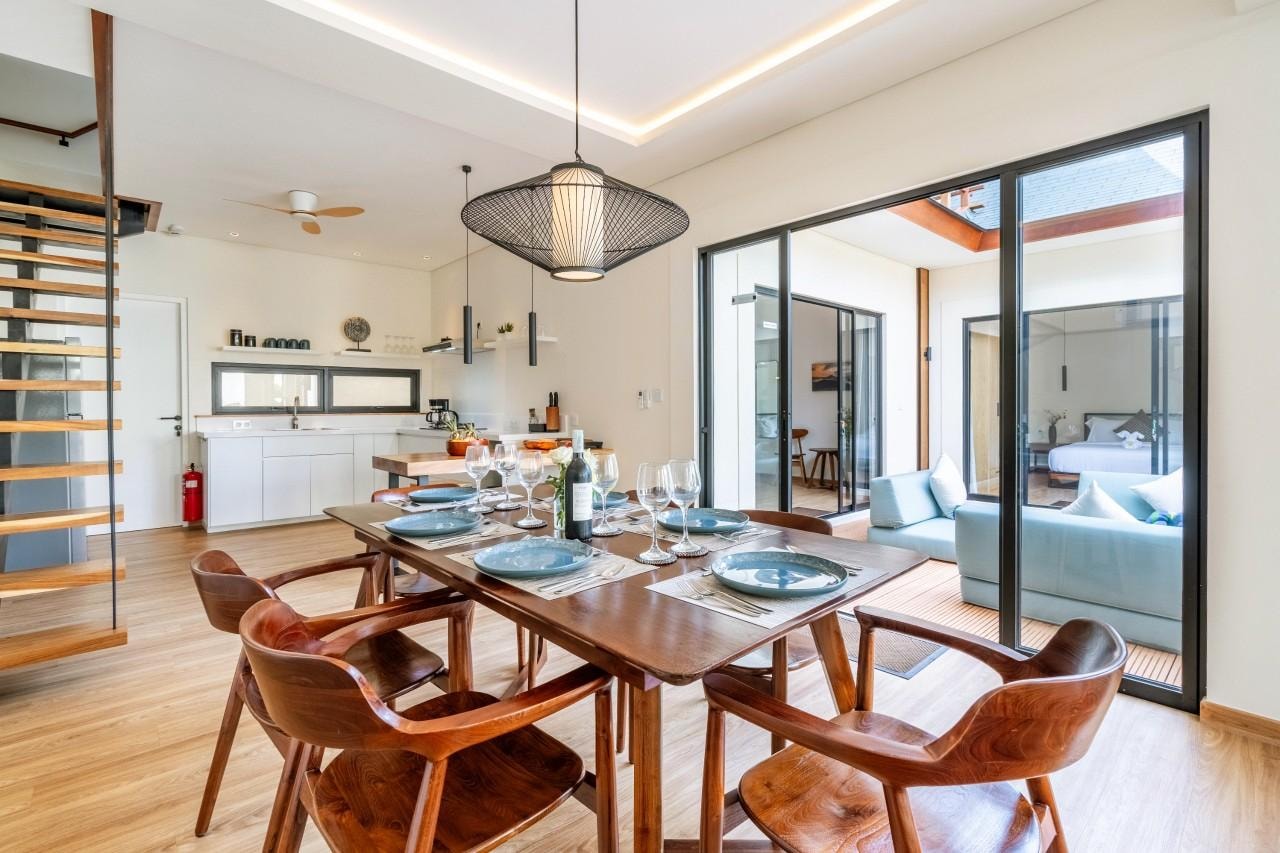 The table set for six beneath the rattan pendant