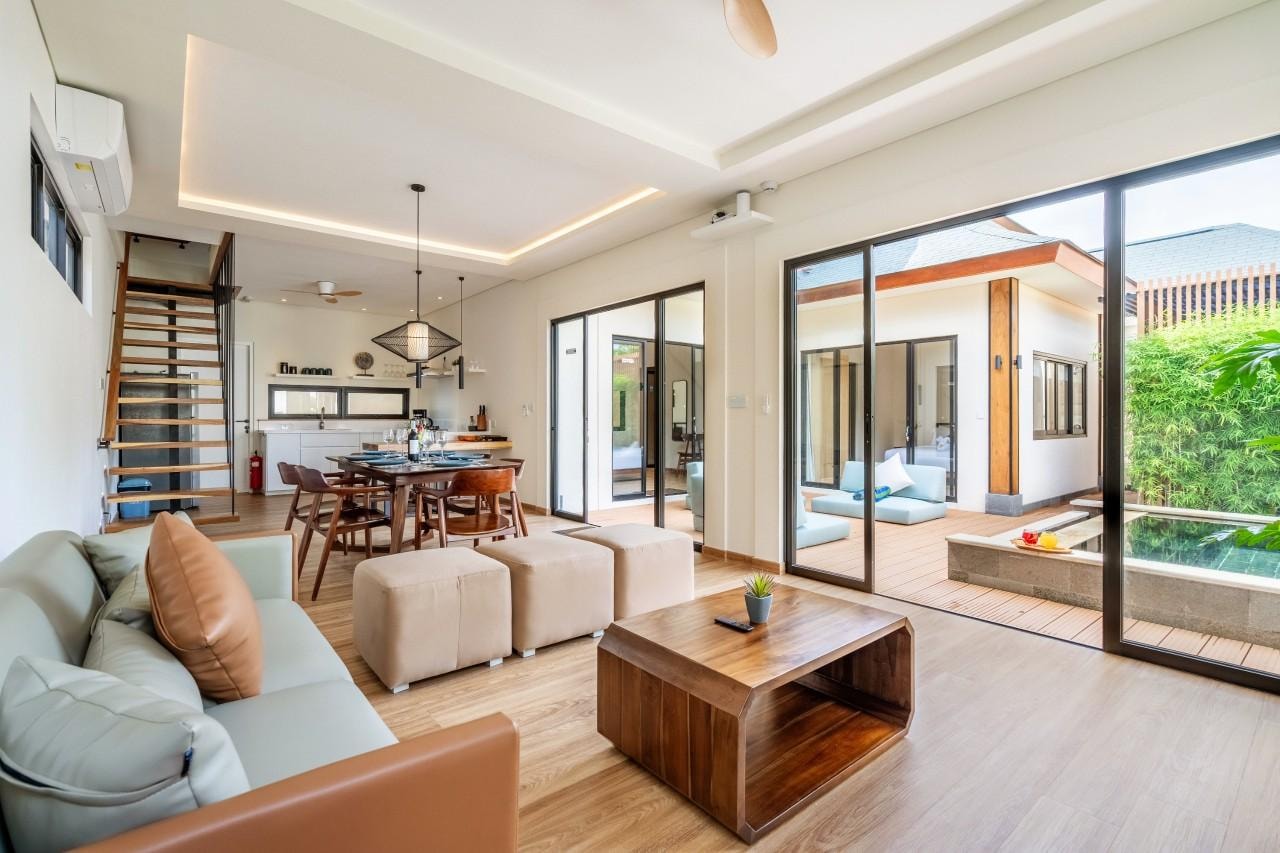 Lounge and dining table in one room, the pool just past the glass