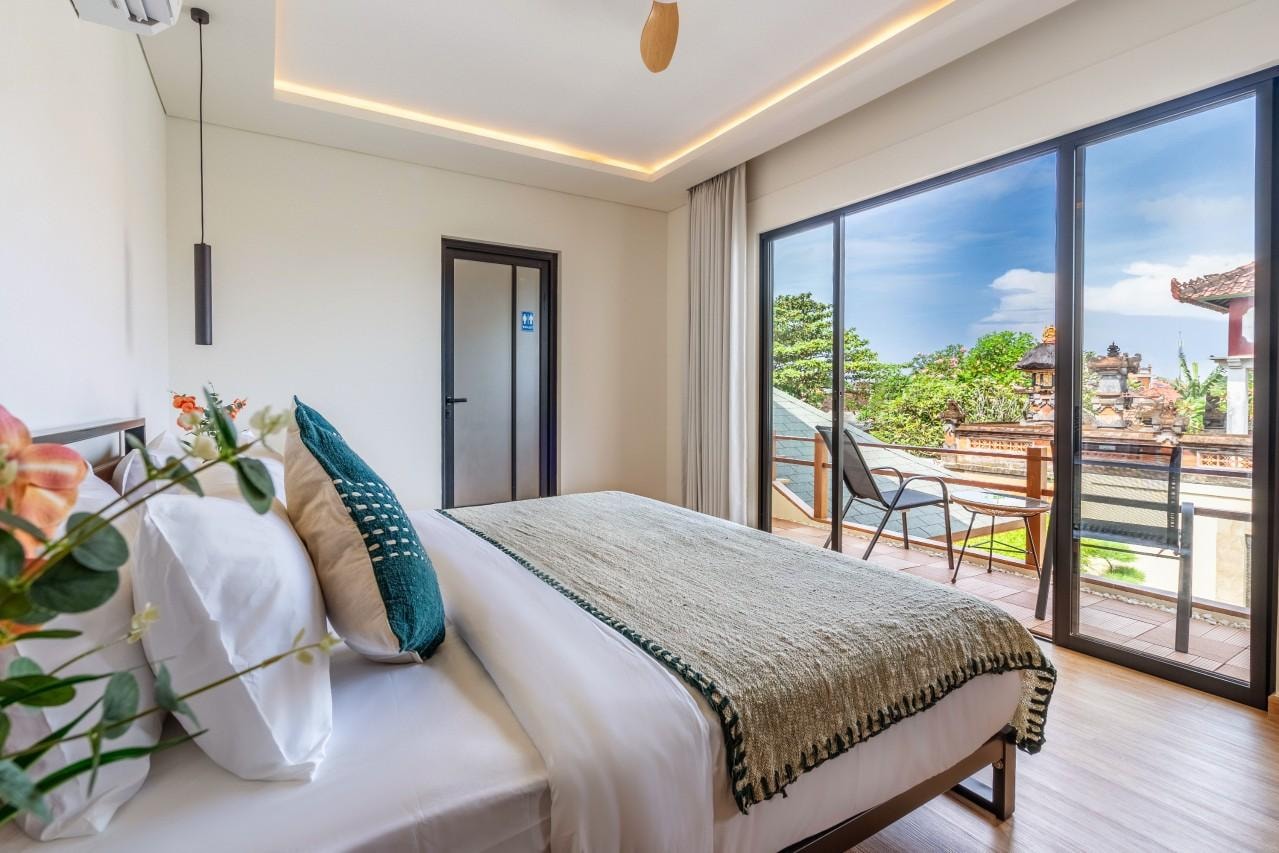 The master suite by day, king-size bed and the balcony doors open to the temple roofs