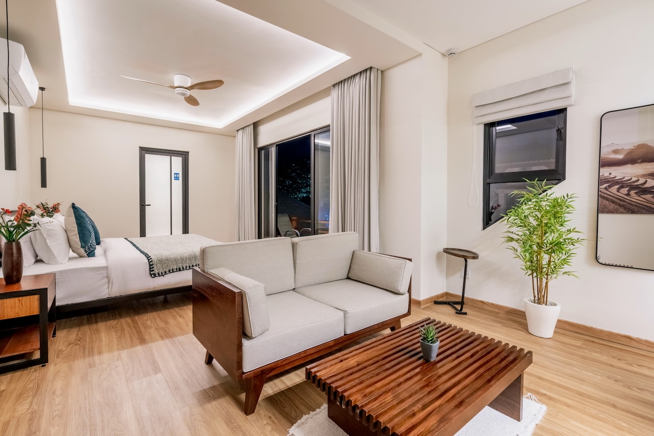 The master suite in the evening: bed, private lounge and the balcony beyond
