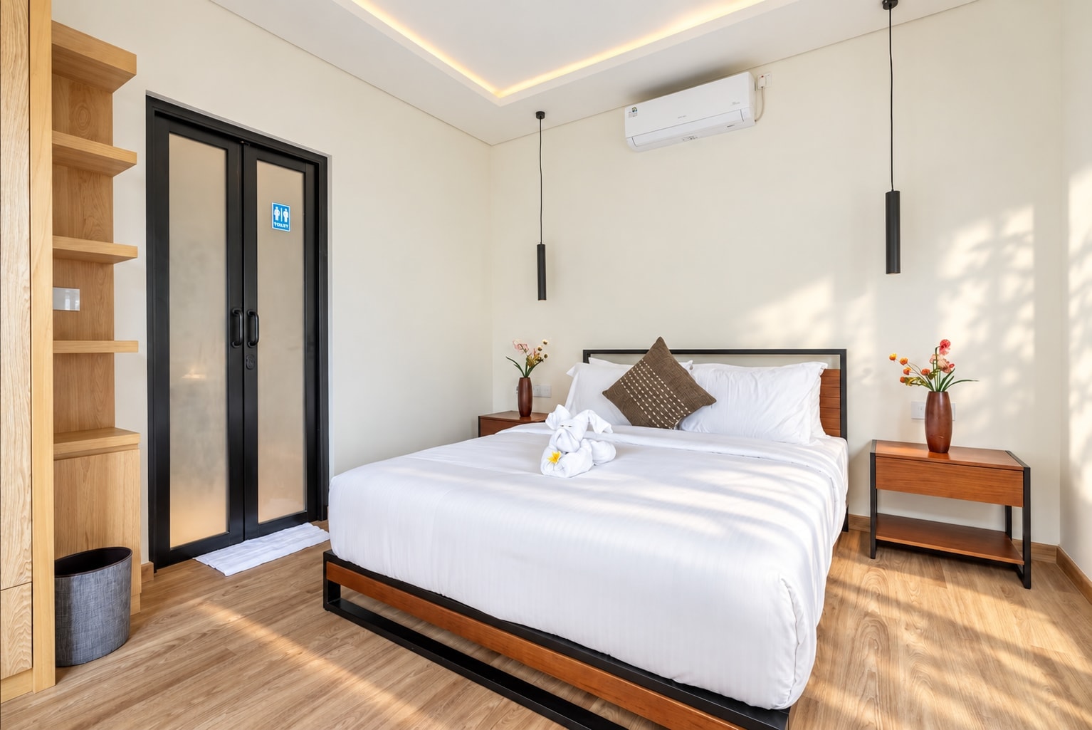 The queen bedroom: bed with timber headboard, open shelving and the door to its en-suite
