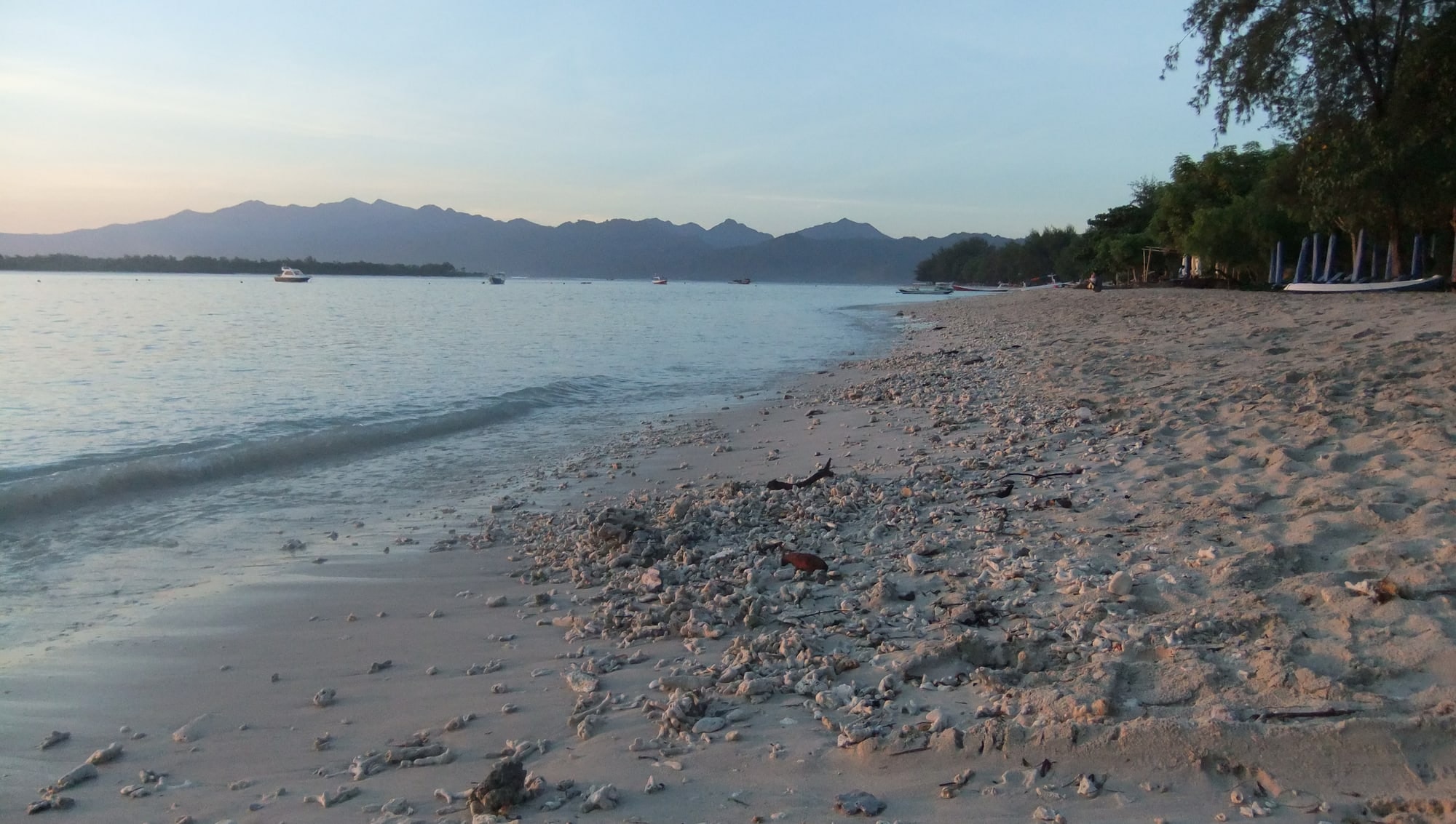 The beach on Gili Trawangan in soft evening light, mountains across the water