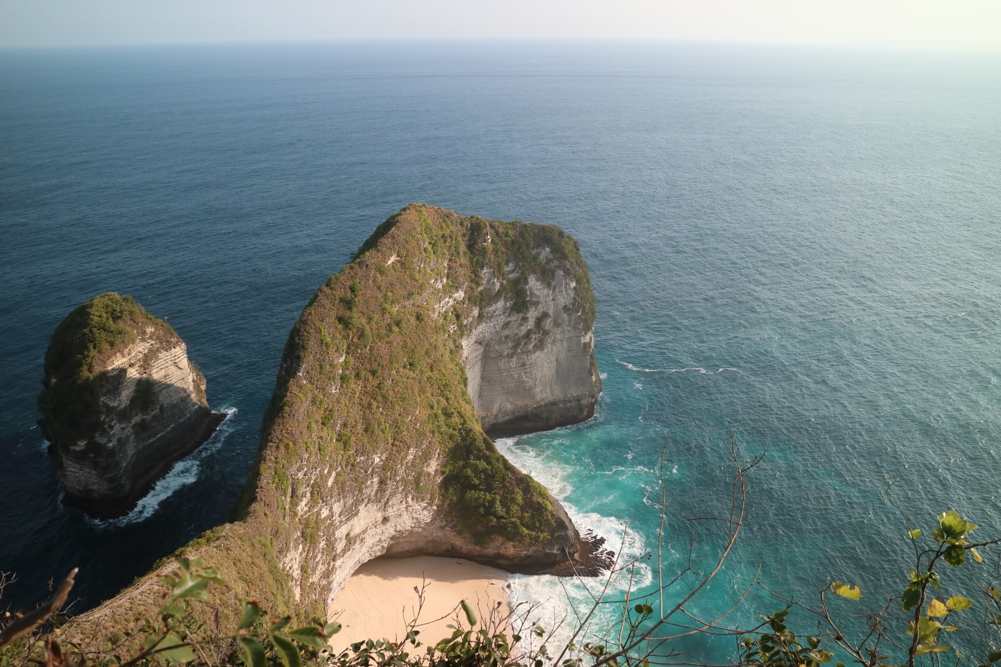 Kelingking Beach on Nusa Penida: a steep green headland above a small white beach and open sea