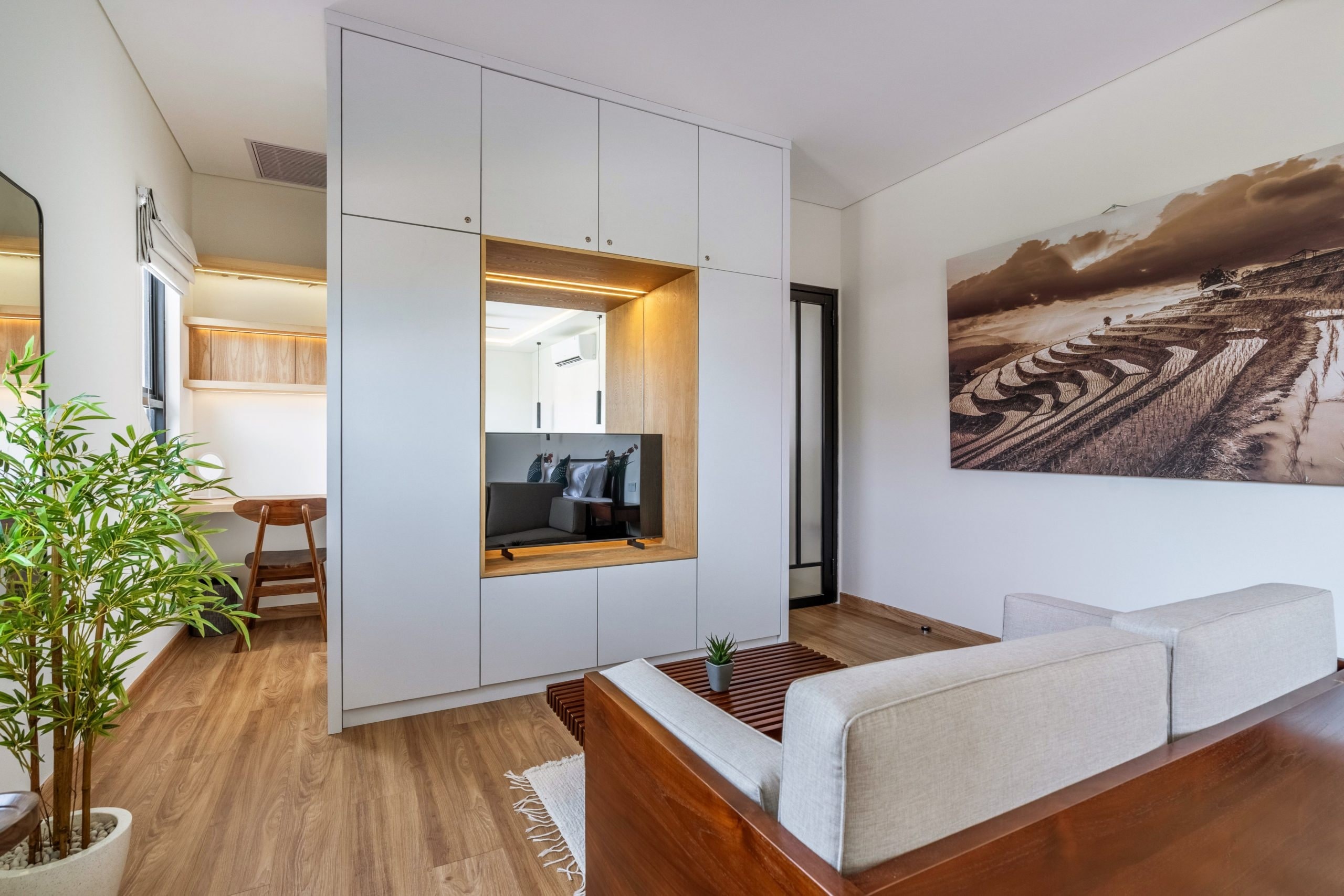 The Master Suite's sitting lounge: the workspace by the window, the sofa and the wardrobe wall with its TV niche