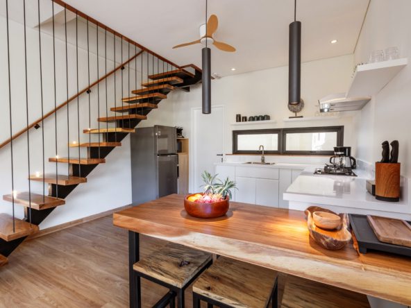 Fully equipped kitchen with refrigerator, stovetop, microwave, tea and coffee maker, water refill and kitchenware.